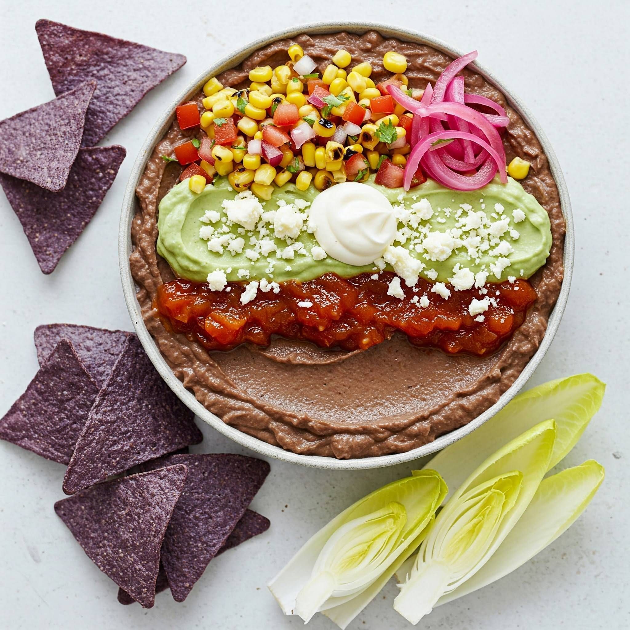 https://storage.tally.so/371a5456-d23e-451d-a280-ebc92aa8de3d/Fancy-7-Layer-Dip--Black-bean-puree-roasted-corn-salsa-avocado-whip-smoky-tomato-jam-queso-fresco-pickled-onion-crema.-Served-with-blue-corn-chips-endive-GF-Veg-.jpg